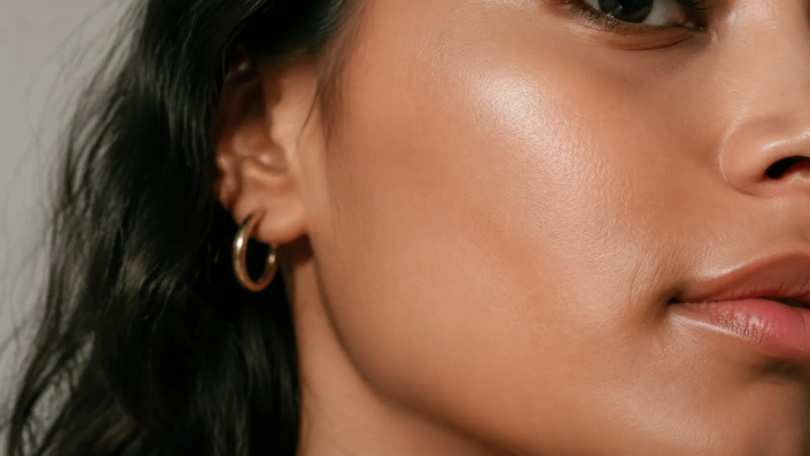 Close-up of a woman's cheek showing smooth, hydrated skin without visible flaking or redness